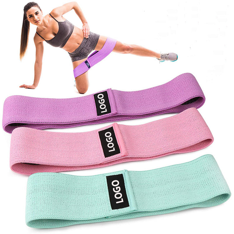 Žena cvičí s fitness squat resistance band, barevné odporové gumy v růžové, fialové a zelené barvě.