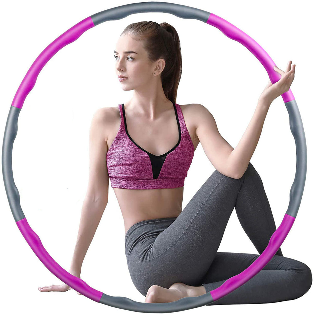 Žena cvičící s fitness ring for exercise v růžové a šedé barvě, relaxační pozice.