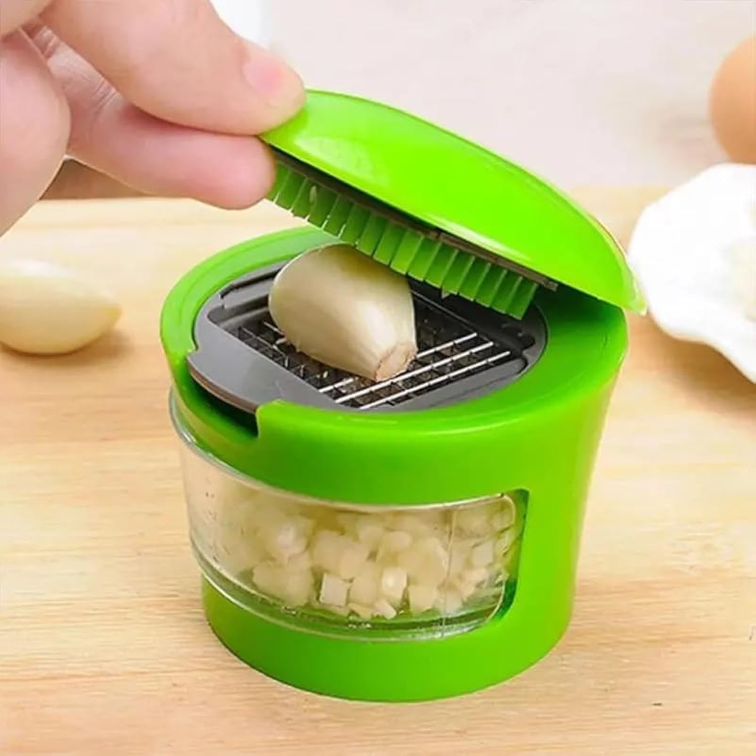 Nerezový lis na česnek kuchyňský gadget v akci, snadné sekání česneku s čerstvou surovinou.