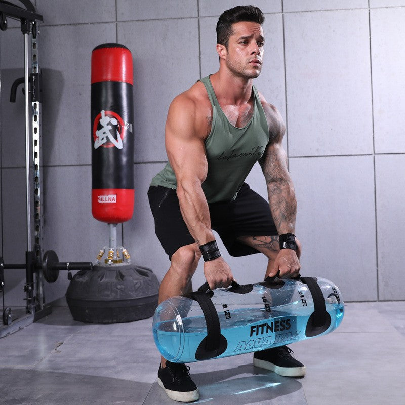 Muž cvičící s transparentním vodním činkem pro fitness v posilovně, zdvihající 5 kg činku.